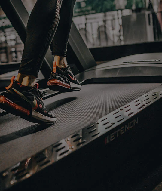 Persona caminando sobre una cinta de correr Etenon en un gimnasio